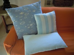 Cuscino piccolo, tessuto artigianalmente con disegno a pesci azzurro, disponibile nella misura cm 50x50.